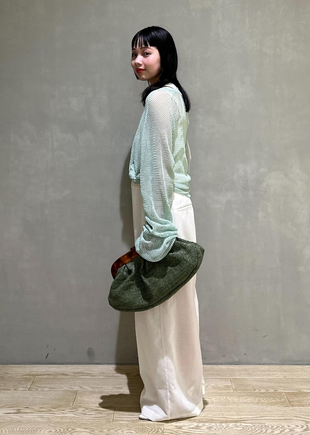 ホワイト系のサンダル、ホワイト系のサロペット/オーバーオール、グリーン系のクラッチバッグを着用したレディースの春コーディネートの3枚目の写真