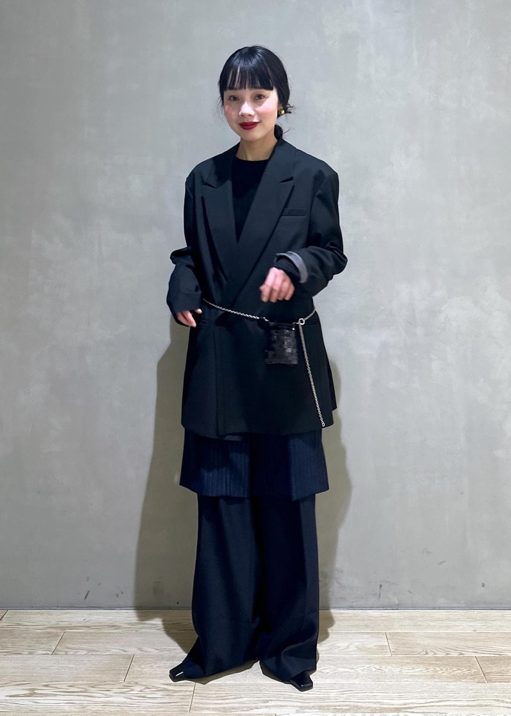 ブラック系のショルダーバッグ、ブラック系のテーラードジャケット、ブラック系のTシャツ/カットソーを着用したレディースの冬コーディネートの2枚目の写真