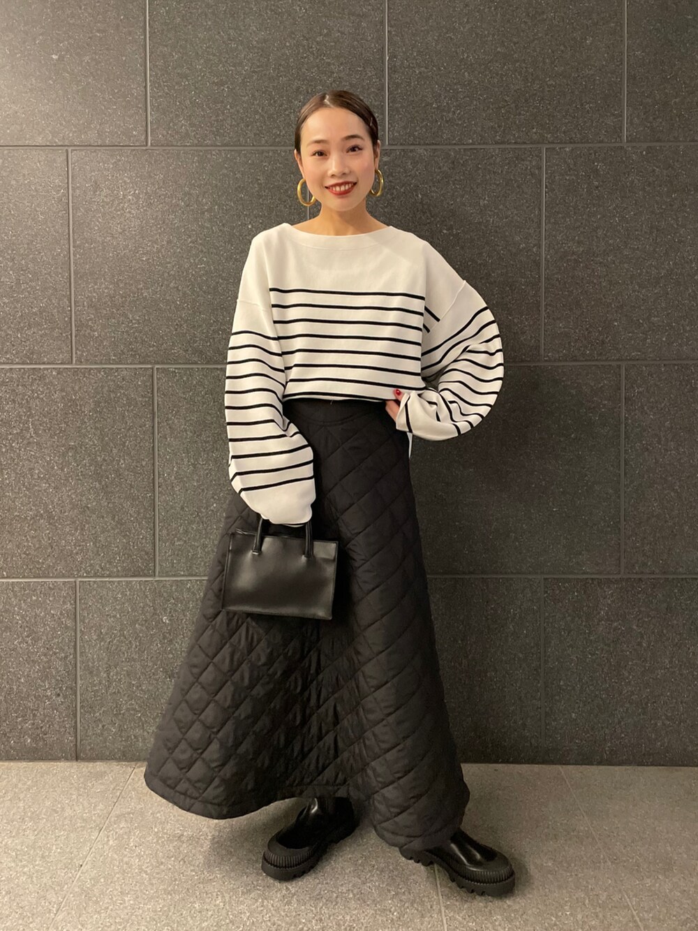 ブラック系のその他アウター、ブラック系のスカート、ブラック系のブーツを着用したレディースの冬コーディネートの4枚目の写真