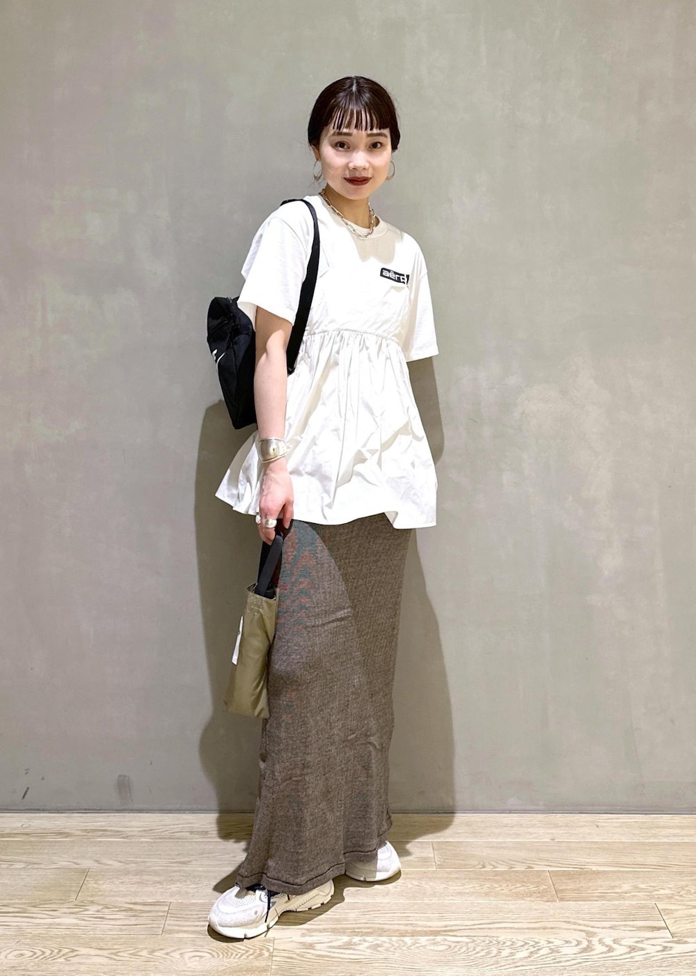 ベージュ系のスカート、ホワイト系のシャツ/ブラウス、ホワイト系のTシャツ/カットソーを着用したレディースの夏コーディネートの2枚目の写真