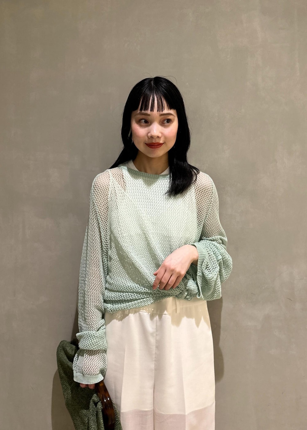 ホワイト系のサンダル、ホワイト系のサロペット/オーバーオール、グリーン系のクラッチバッグを着用したレディースの春コーディネートの6枚目の写真