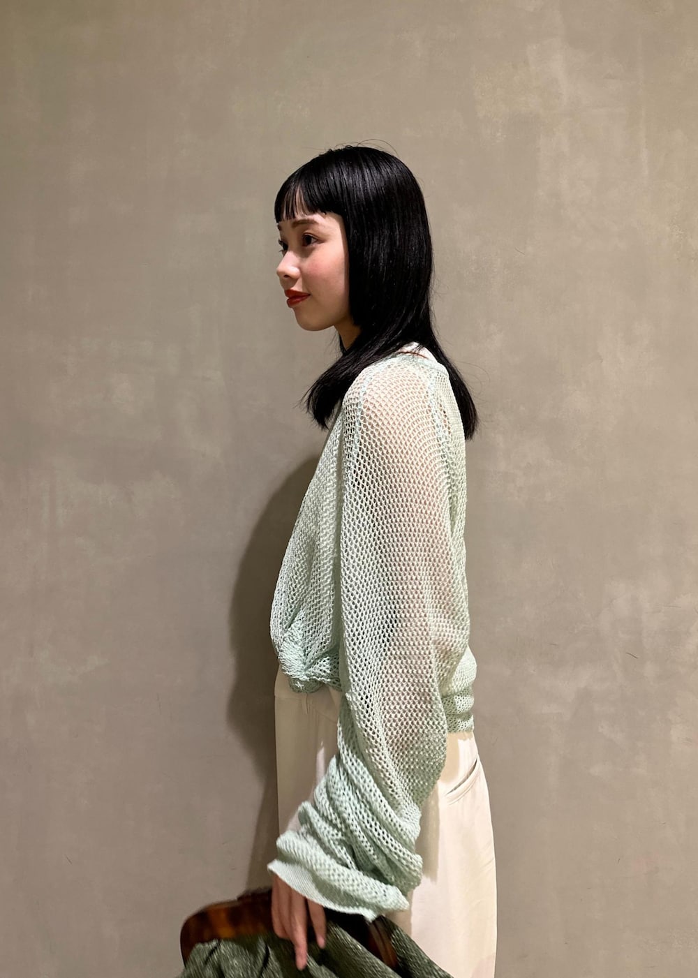 ホワイト系のサンダル、ホワイト系のサロペット/オーバーオール、グリーン系のクラッチバッグを着用したレディースの春コーディネートの7枚目の写真