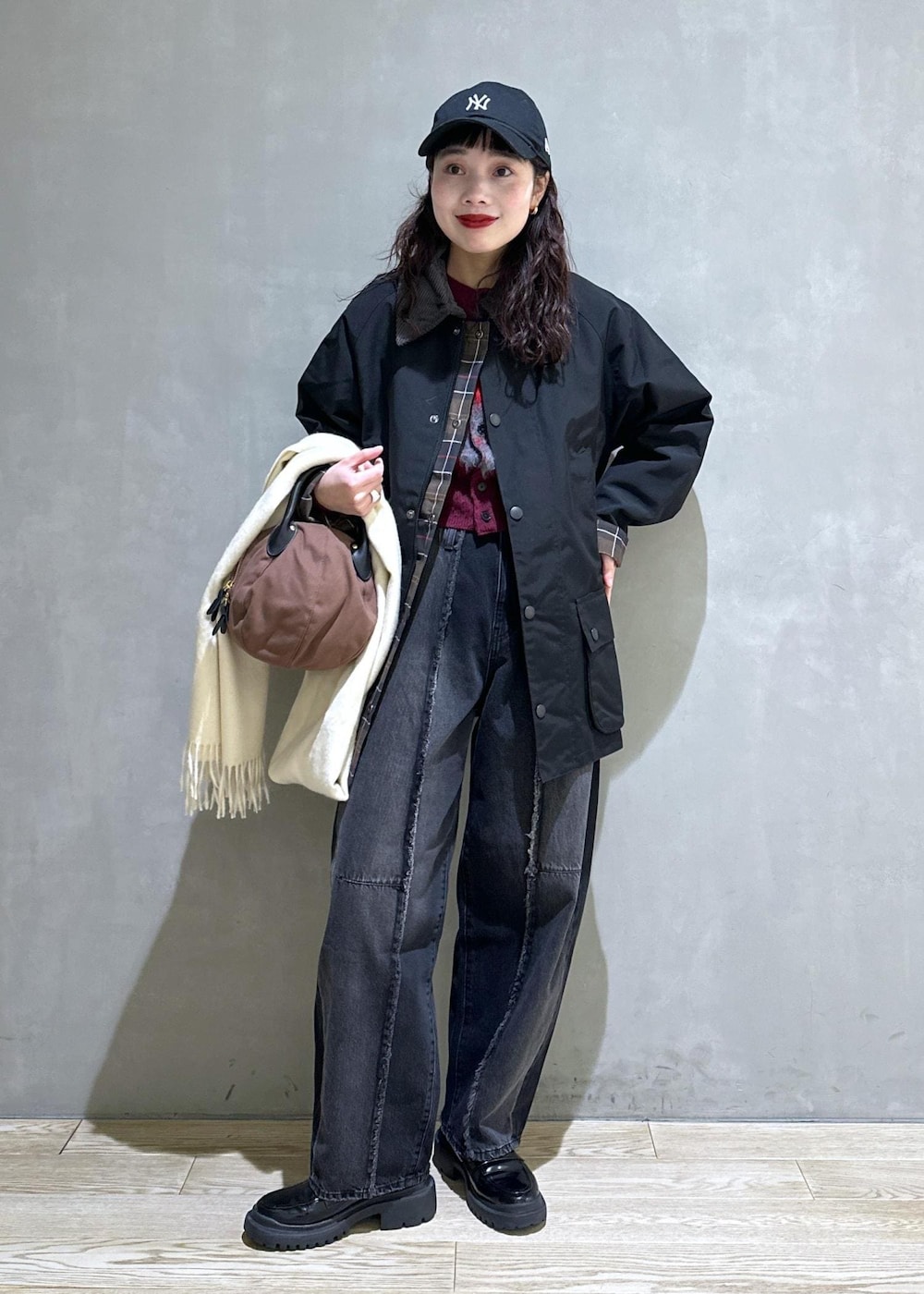 ブラック系のブルゾン、ブラック系のローファー、ブラック系のデニムパンツを着用したレディースの冬コーディネートの2枚目の写真