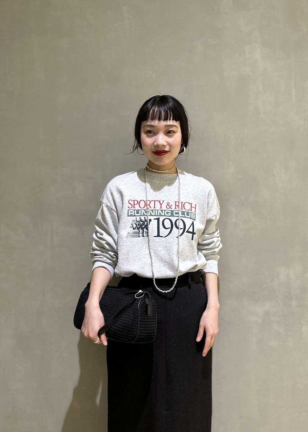 ブラック系のハンドバッグ、ブラック系のスカートを着用したレディースの秋コーディネートの5枚目の写真