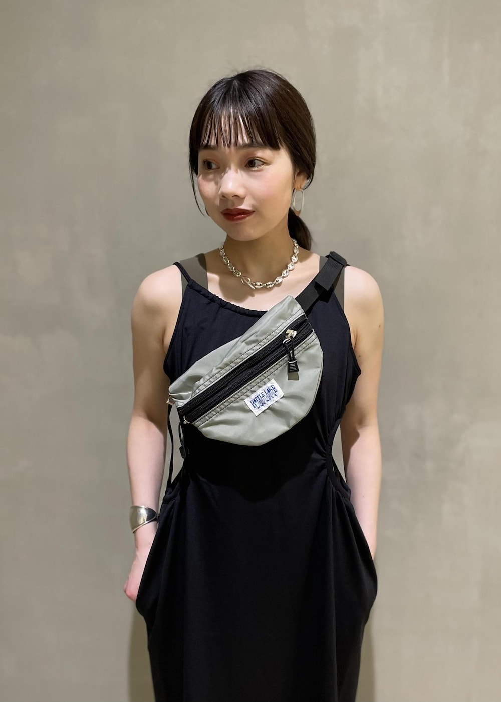 グレー系のボディバッグ/ウエストポーチ、ブラック系のブーツ、ブラック系のワンピースを着用したレディースの春コーディネートの4枚目の写真