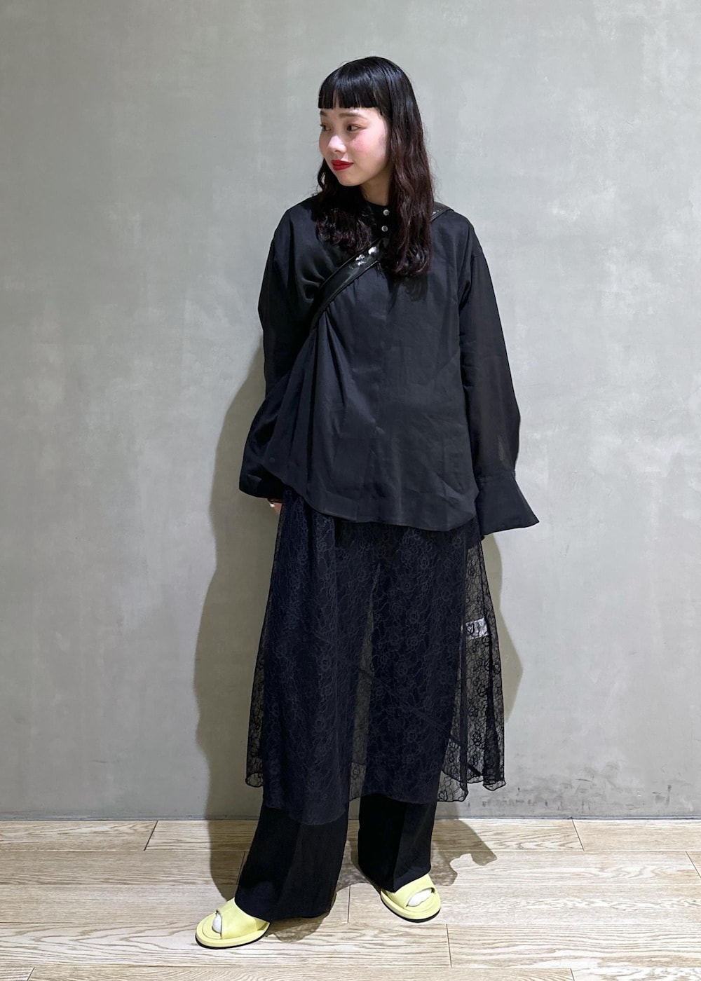 ブラック系のシャツ/ブラウス、ブラック系のショルダーバッグ、グリーン系のサンダルを着用したレディースの春コーディネートの2枚目の写真