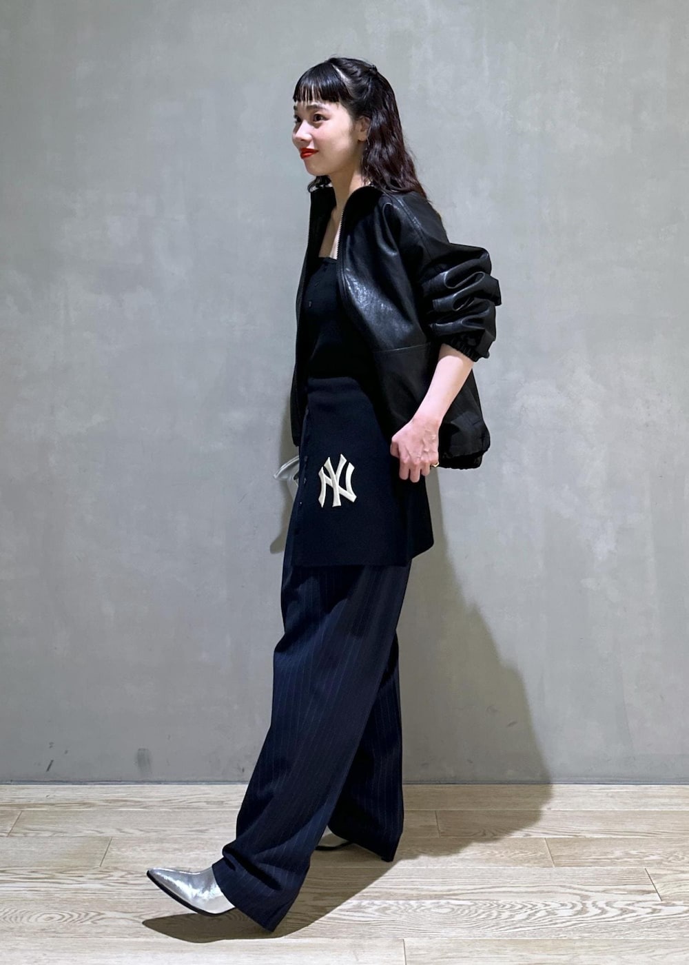 シルバー系のショルダーバッグ、シルバー系のブーツ、ブラック系のスラックスを着用したレディースの秋コーディネートの4枚目の写真