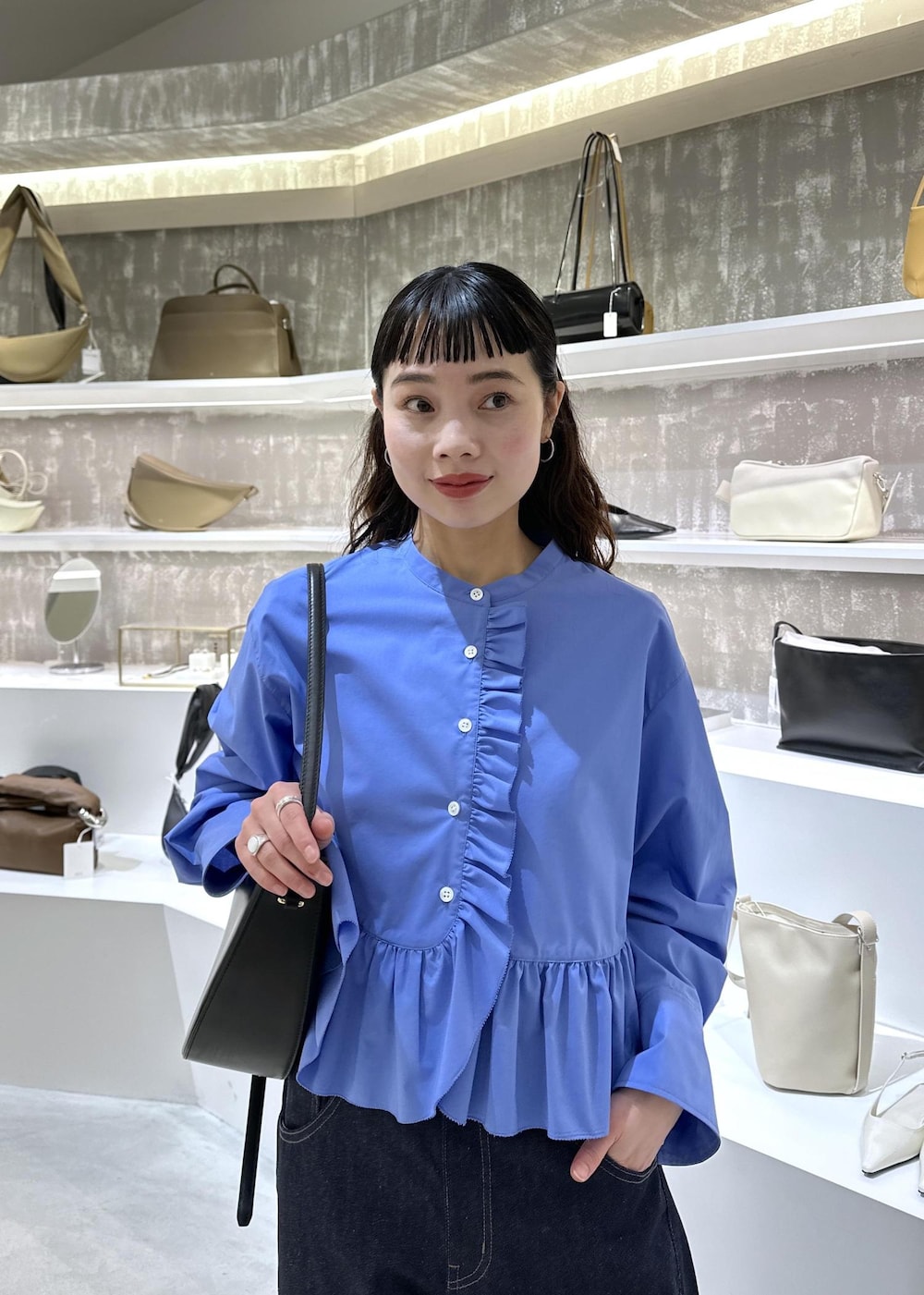 ブラック系のショルダーバッグ、ブルー系のデニムパンツ、ブルー系のシャツ/ブラウスを着用したレディースの春コーディネートの6枚目の写真