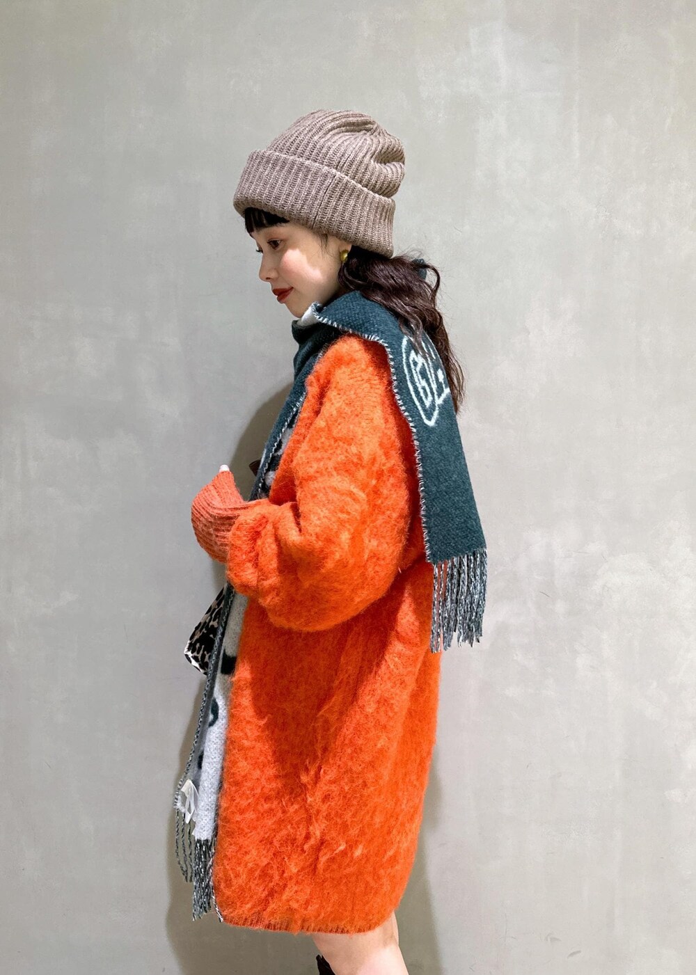 ベージュ系のトートバッグ、オレンジ系のワンピース、ブラウン系のシュシュを着用したレディースの秋コーディネートの9枚目の写真