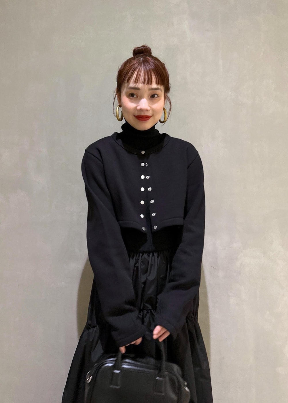 ブラック系のボストンバッグ、ブラック系のブーツ、ブラック系のカーディガン/ボレロを着用したレディースの秋コーディネートの6枚目の写真