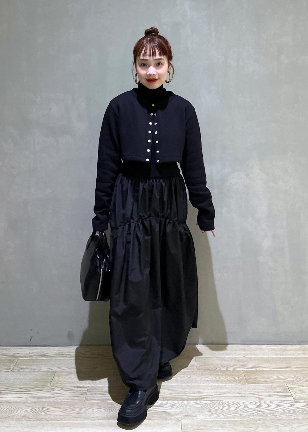 ブラック系のボストンバッグ、ブラック系のブーツ、ブラック系のカーディガン/ボレロを着用したレディースの秋コーディネートの2枚目の写真