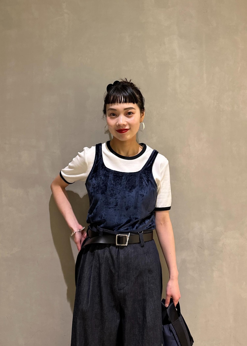 ブルー系のデニムパンツ、ブルー系のショルダーバッグ、ブルー系のタンクトップを着用したレディースの夏コーディネートの6枚目の写真