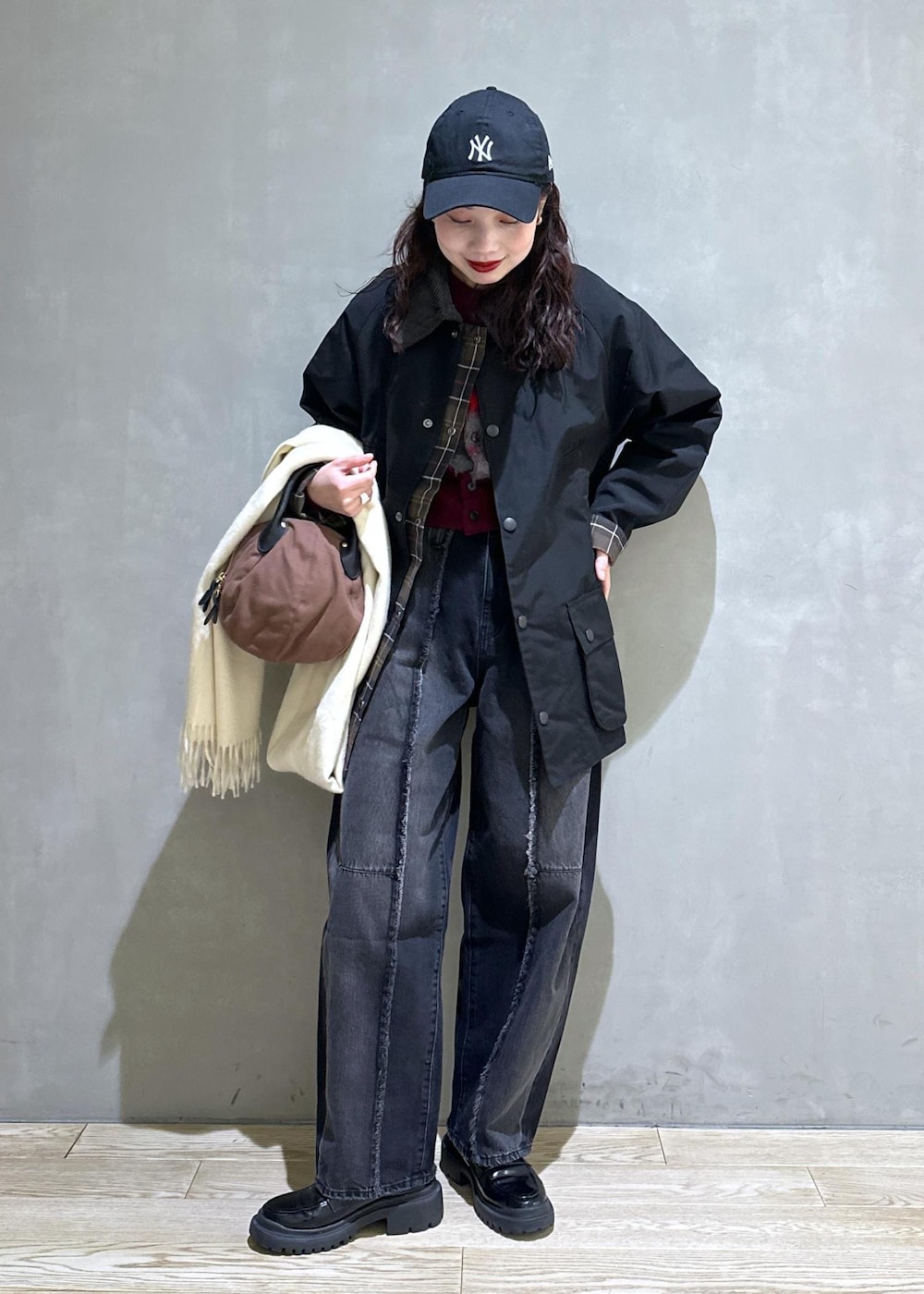 ブラック系のブルゾン、ブラック系のローファー、ブラック系のデニムパンツを着用したレディースの冬コーディネートの3枚目の写真