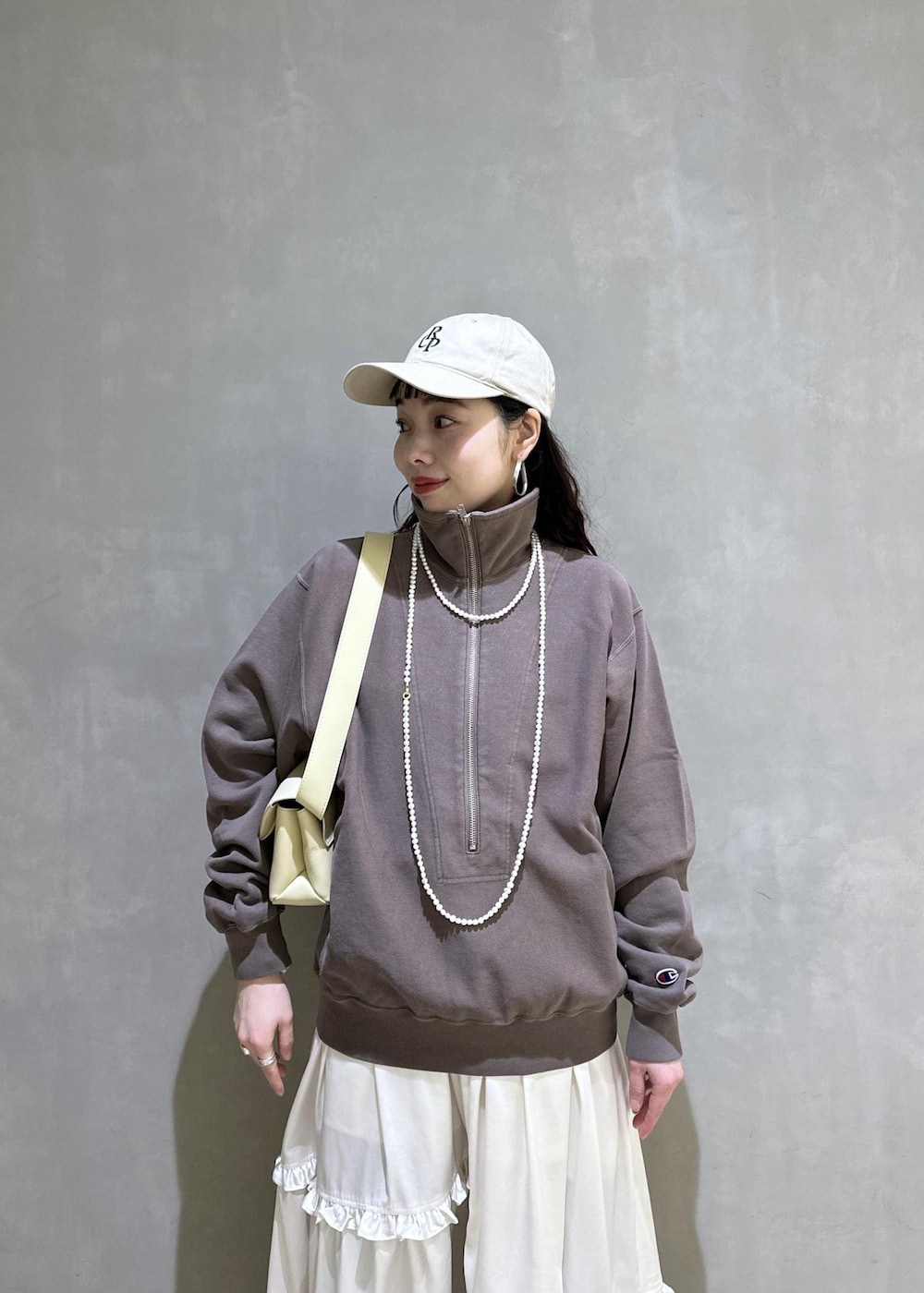 ホワイト系のスカート、ブラウン系のスウェット、ベージュ系のサンダルを着用したレディースの冬コーディネートの10枚目の写真