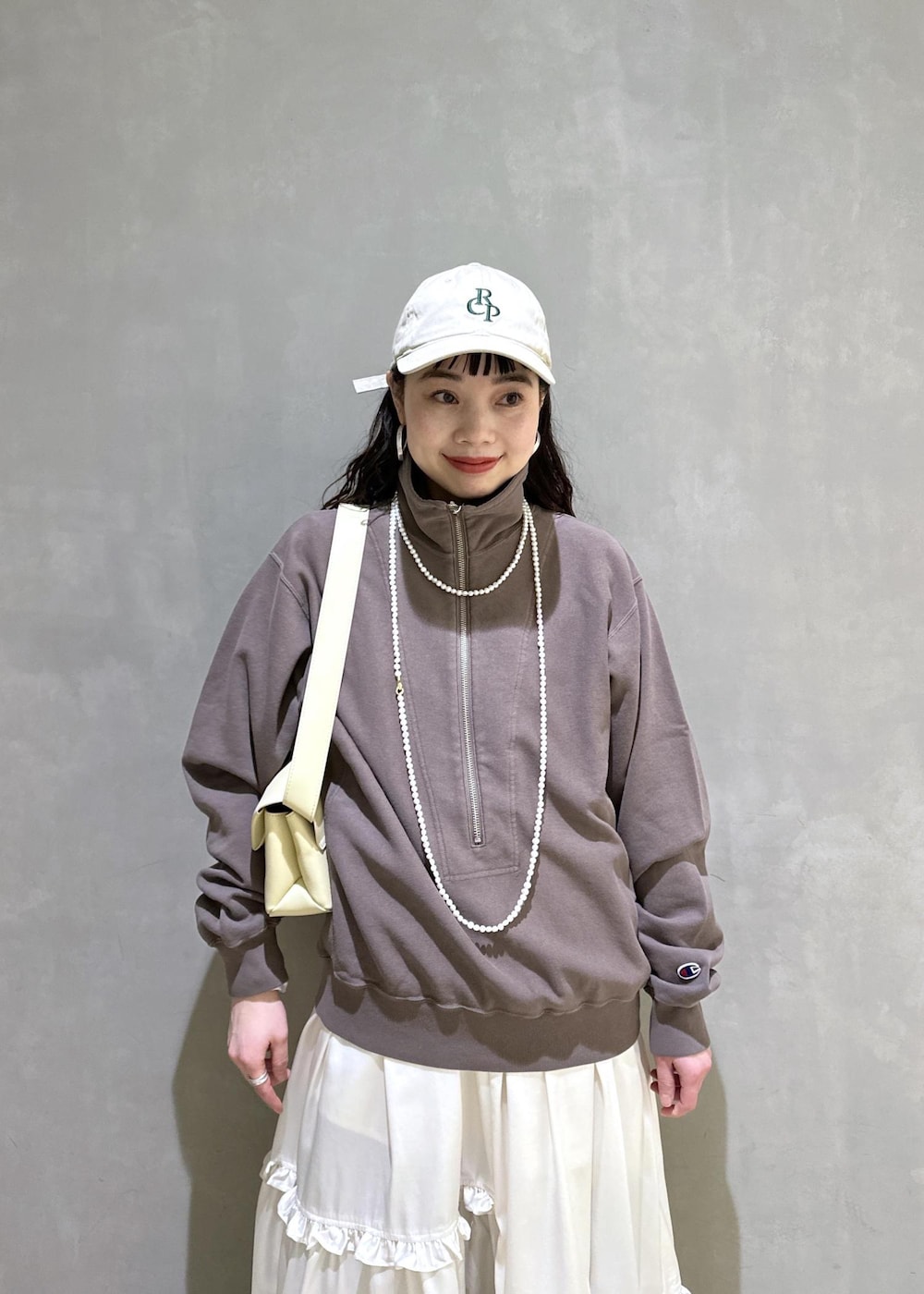 ホワイト系のスカート、ブラウン系のスウェット、ベージュ系のサンダルを着用したレディースの冬コーディネートの6枚目の写真