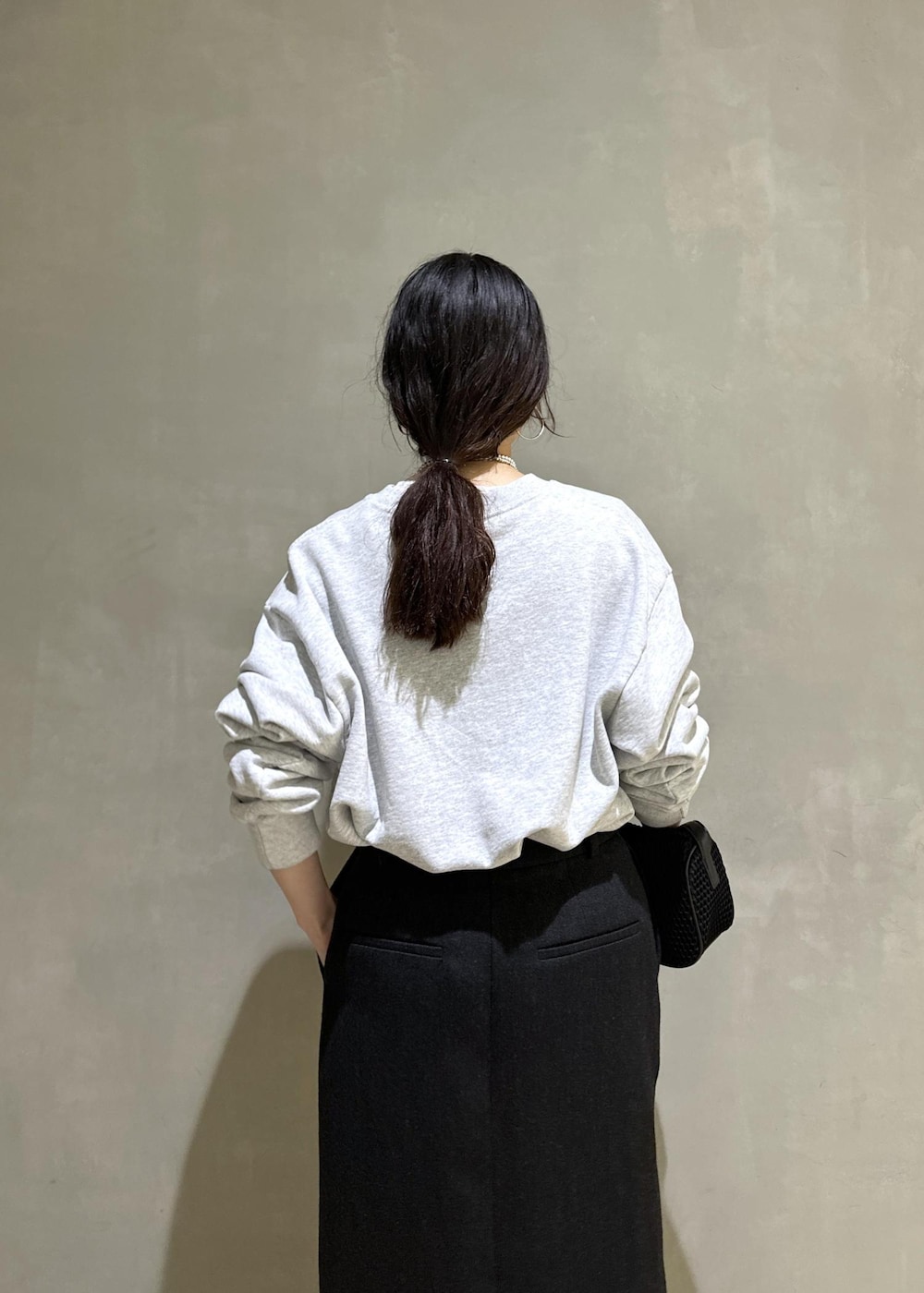 ブラック系のハンドバッグ、ブラック系のスカートを着用したレディースの秋コーディネートの8枚目の写真