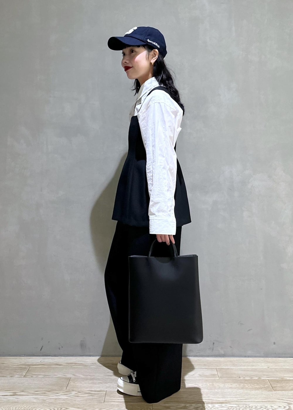 ブラック系のトートバッグ、ブラック系のつなぎ/オールインワンを着用したレディースの冬コーディネートの4枚目の写真