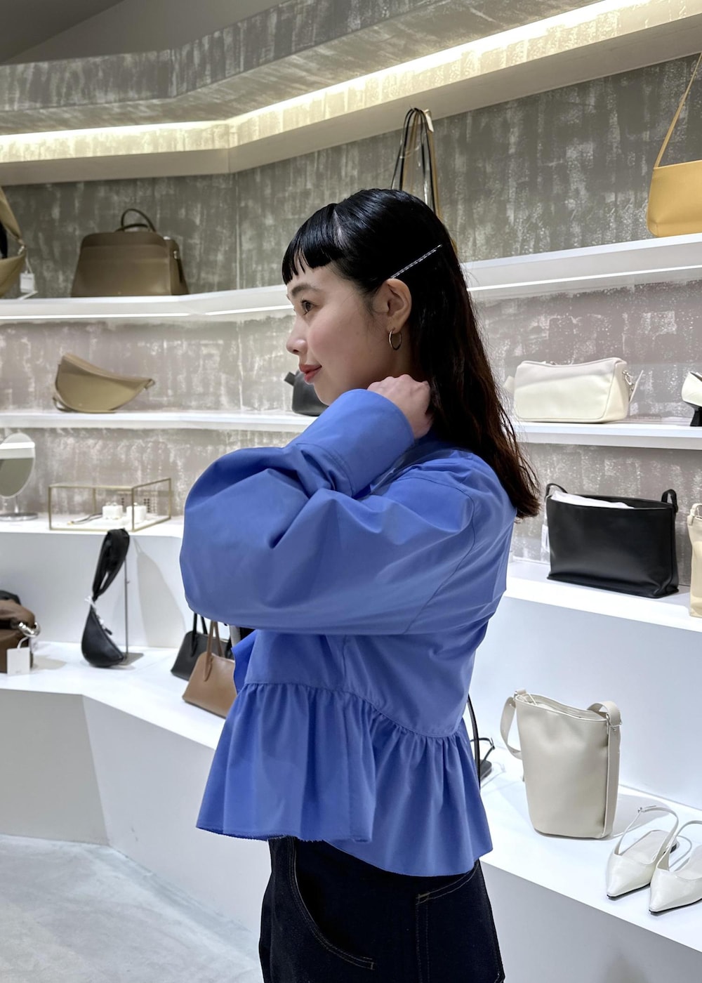 ブラック系のショルダーバッグ、ブルー系のデニムパンツ、ブルー系のシャツ/ブラウスを着用したレディースの春コーディネートの7枚目の写真