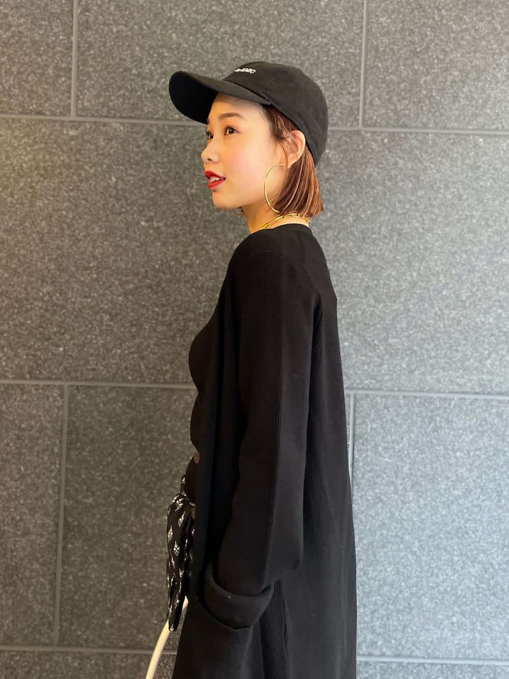 ブラック系のカーディガン/ボレロ、ブルー系のデニムパンツ、レッド系のスニーカーを着用したレディースの冬コーディネートの4枚目の写真