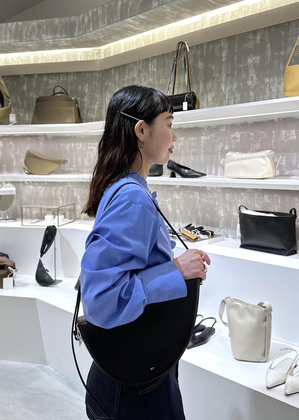 ブラック系のショルダーバッグ、ブルー系のデニムパンツ、ブルー系のシャツ/ブラウスを着用したレディースの春コーディネートの9枚目の写真