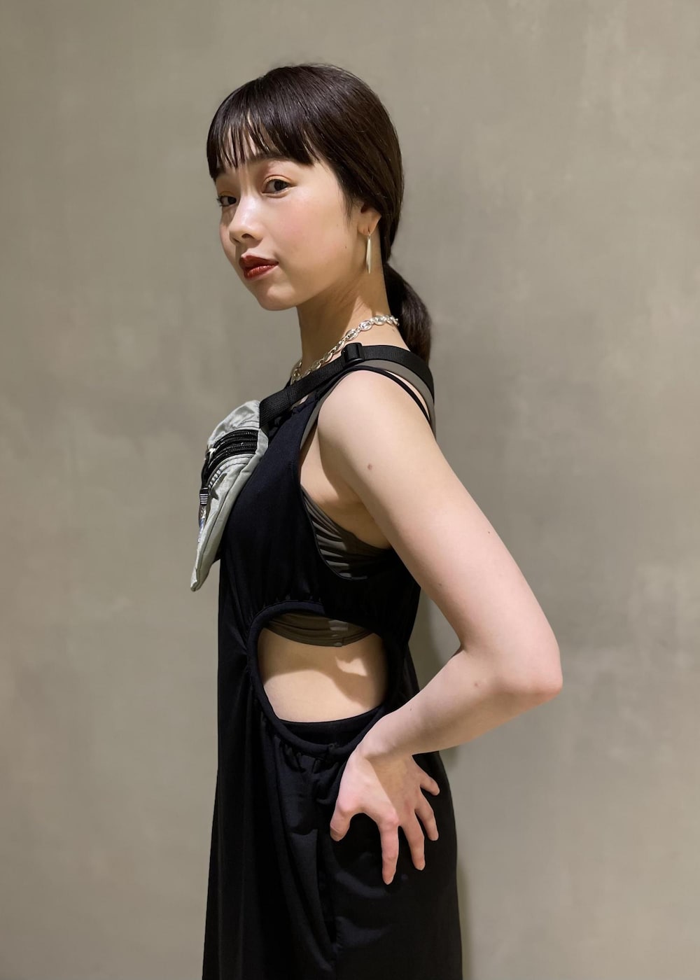 グレー系のボディバッグ/ウエストポーチ、ブラック系のブーツ、ブラック系のワンピースを着用したレディースの春コーディネートの5枚目の写真