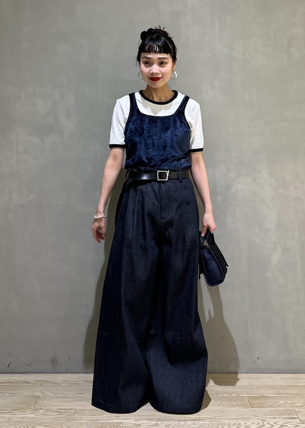 ブルー系のデニムパンツ、ブルー系のショルダーバッグ、ブルー系のタンクトップを着用したレディースの夏コーディネートの2枚目の写真