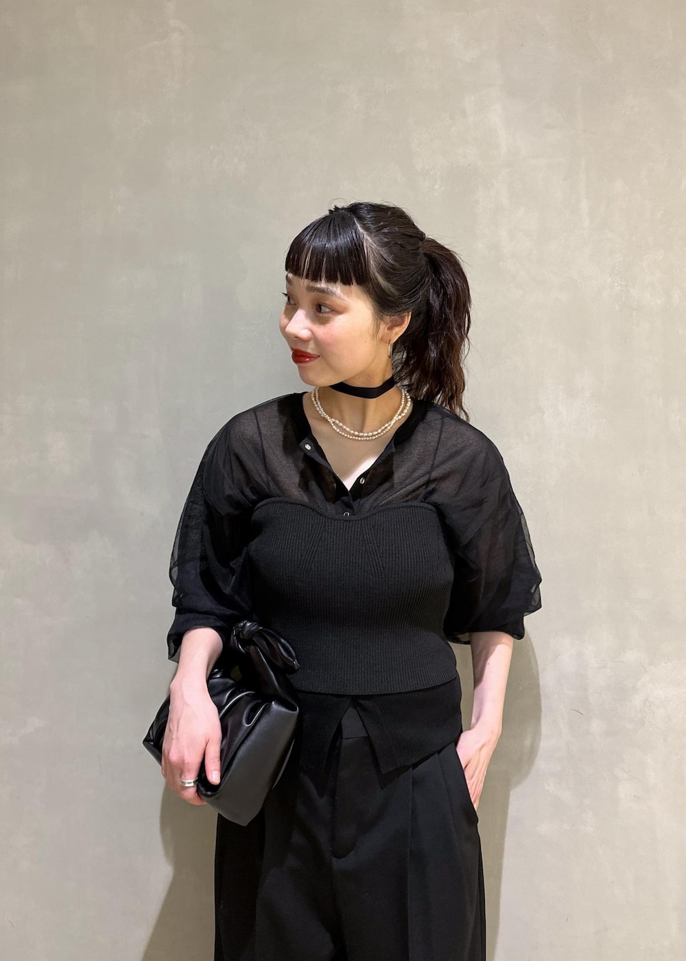 ブラック系のカーディガン/ボレロ、ブラック系のスラックス、ブラック系のショルダーバッグを着用したレディースの夏コーディネートの5枚目の写真
