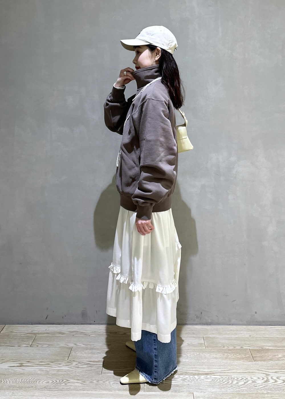 ホワイト系のスカート、ブラウン系のスウェット、ベージュ系のサンダルを着用したレディースの冬コーディネートの3枚目の写真