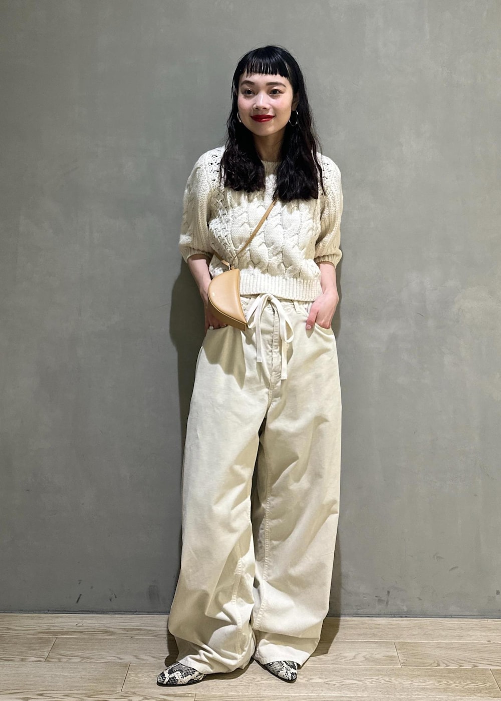 ホワイト系のその他パンツ、ホワイト系のニット/セーター、イエロー系のキーホルダーを着用したレディースの秋コーディネートの2枚目の写真