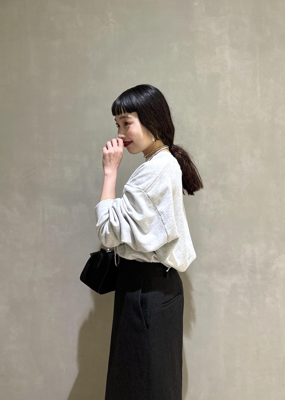 ブラック系のハンドバッグ、ブラック系のスカートを着用したレディースの秋コーディネートの7枚目の写真