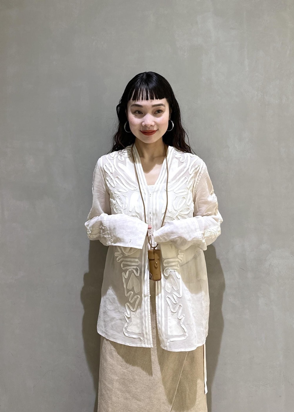 ベージュ系のスカート、ホワイト系のシャツ/ブラウス、ブルー系のデニムパンツを着用したレディースの冬コーディネートの5枚目の写真