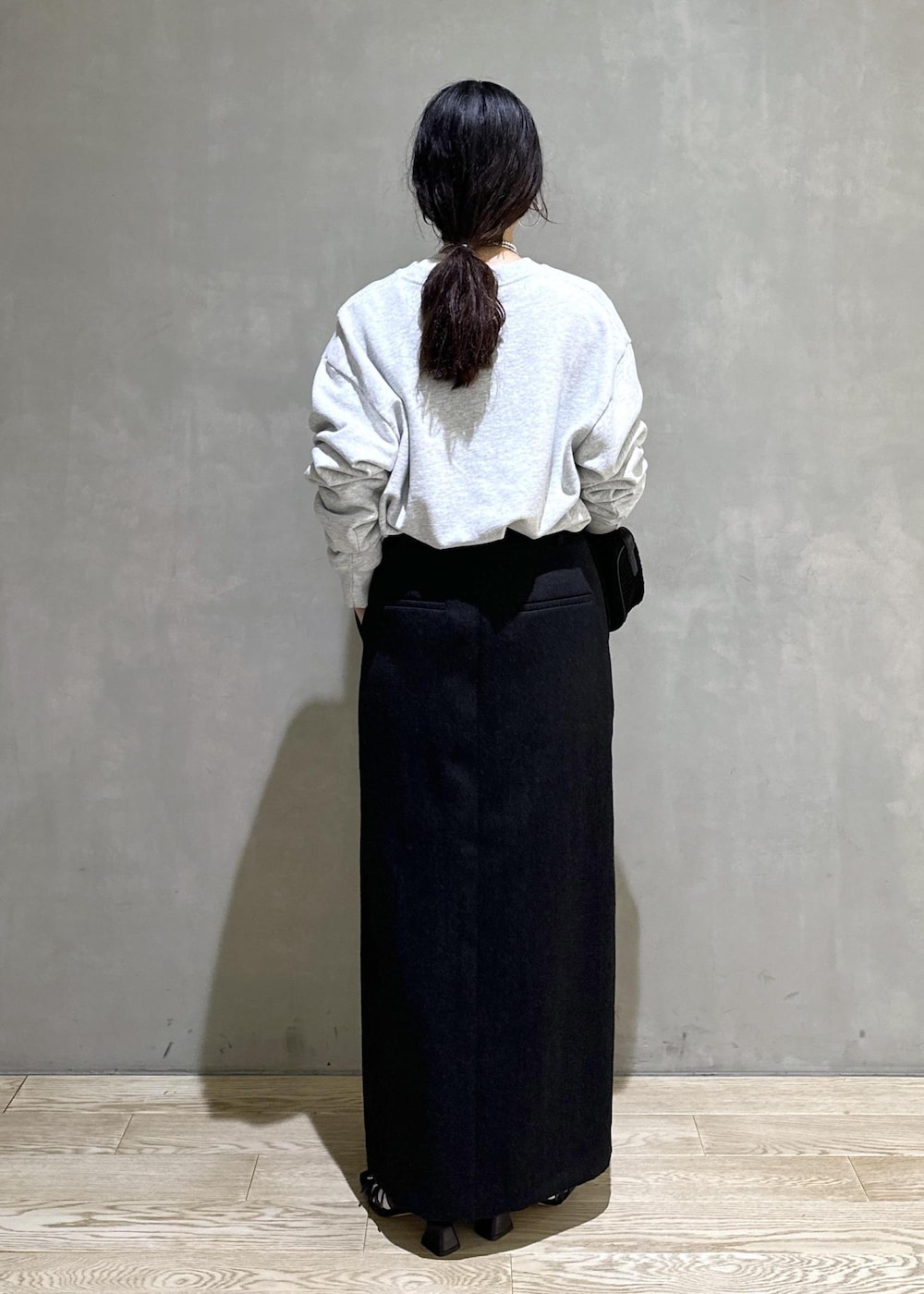 ブラック系のハンドバッグ、ブラック系のスカートを着用したレディースの秋コーディネートの3枚目の写真