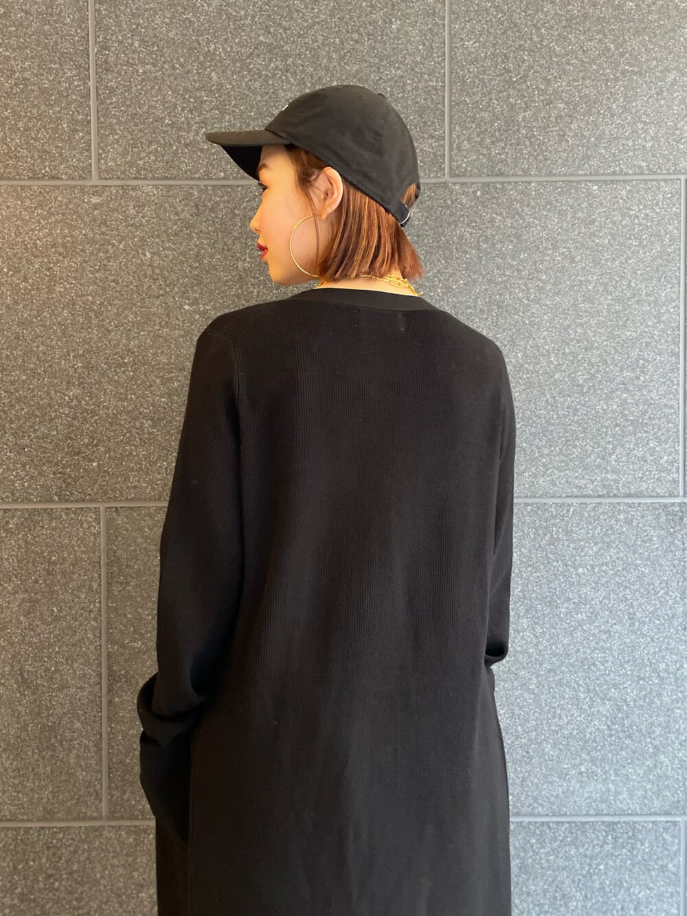 ブラック系のカーディガン/ボレロ、ブルー系のデニムパンツ、レッド系のスニーカーを着用したレディースの冬コーディネートの5枚目の写真