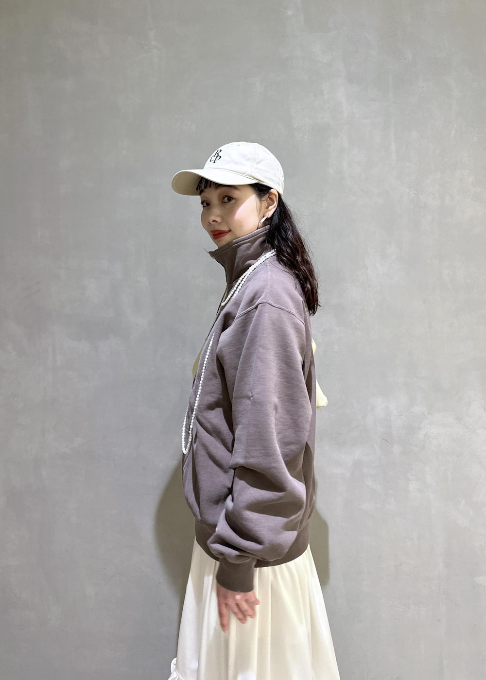 ホワイト系のスカート、ブラウン系のスウェット、ベージュ系のサンダルを着用したレディースの冬コーディネートの7枚目の写真