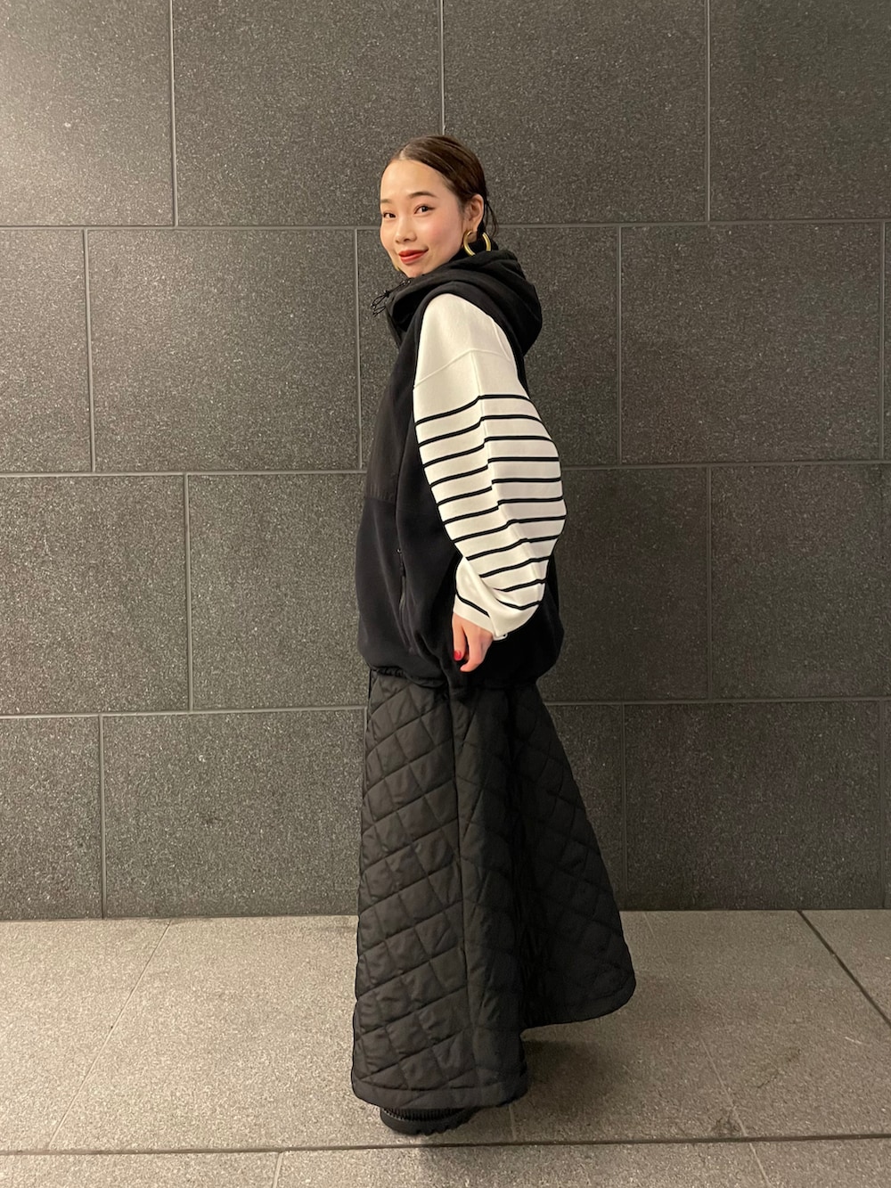 ブラック系のその他アウター、ブラック系のスカート、ブラック系のブーツを着用したレディースの冬コーディネートの2枚目の写真