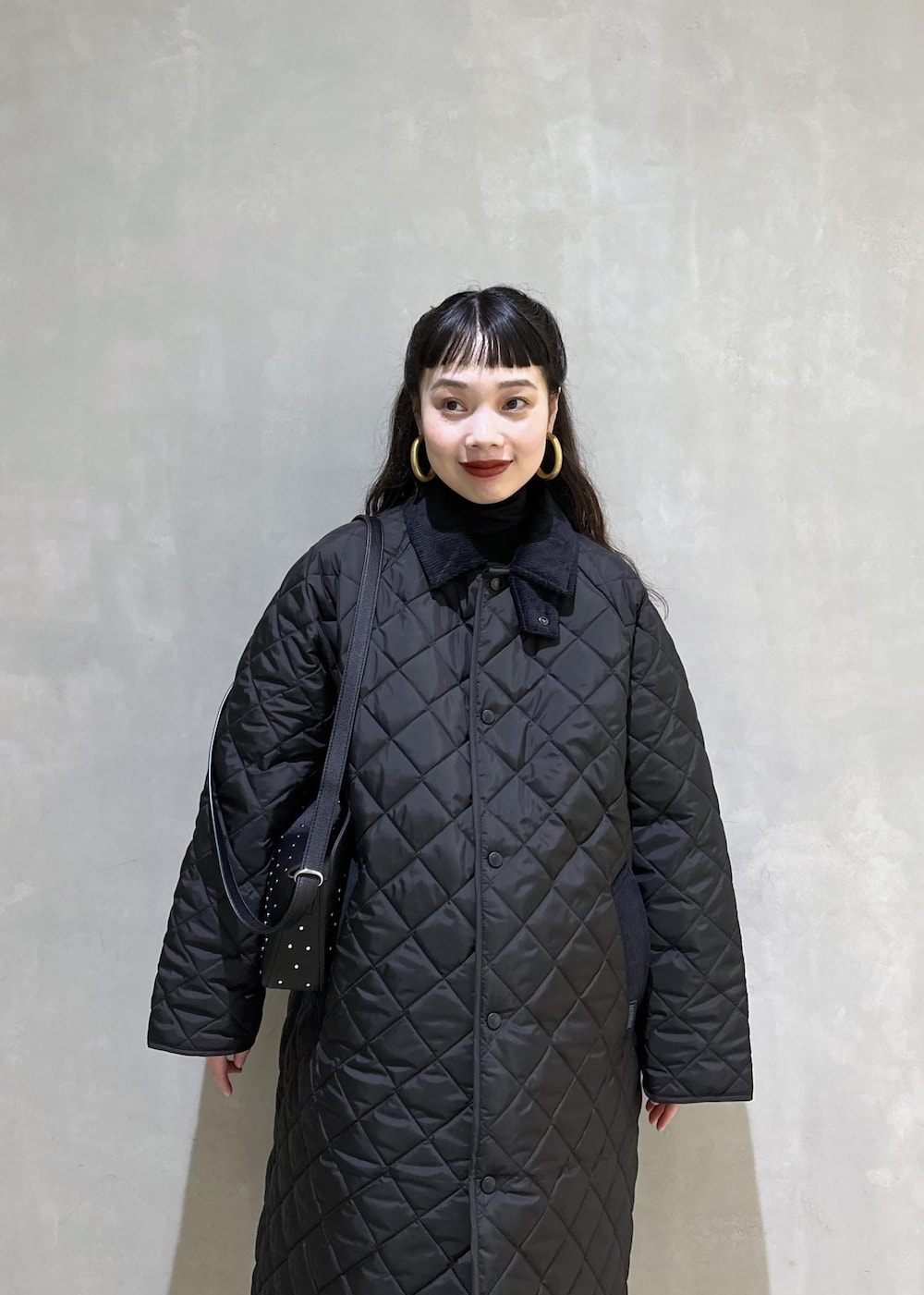 ブラック系のニット/セーター、ブラック系のナイロンジャケット、ブラック系のブーツを着用したレディースの秋コーディネートの9枚目の写真