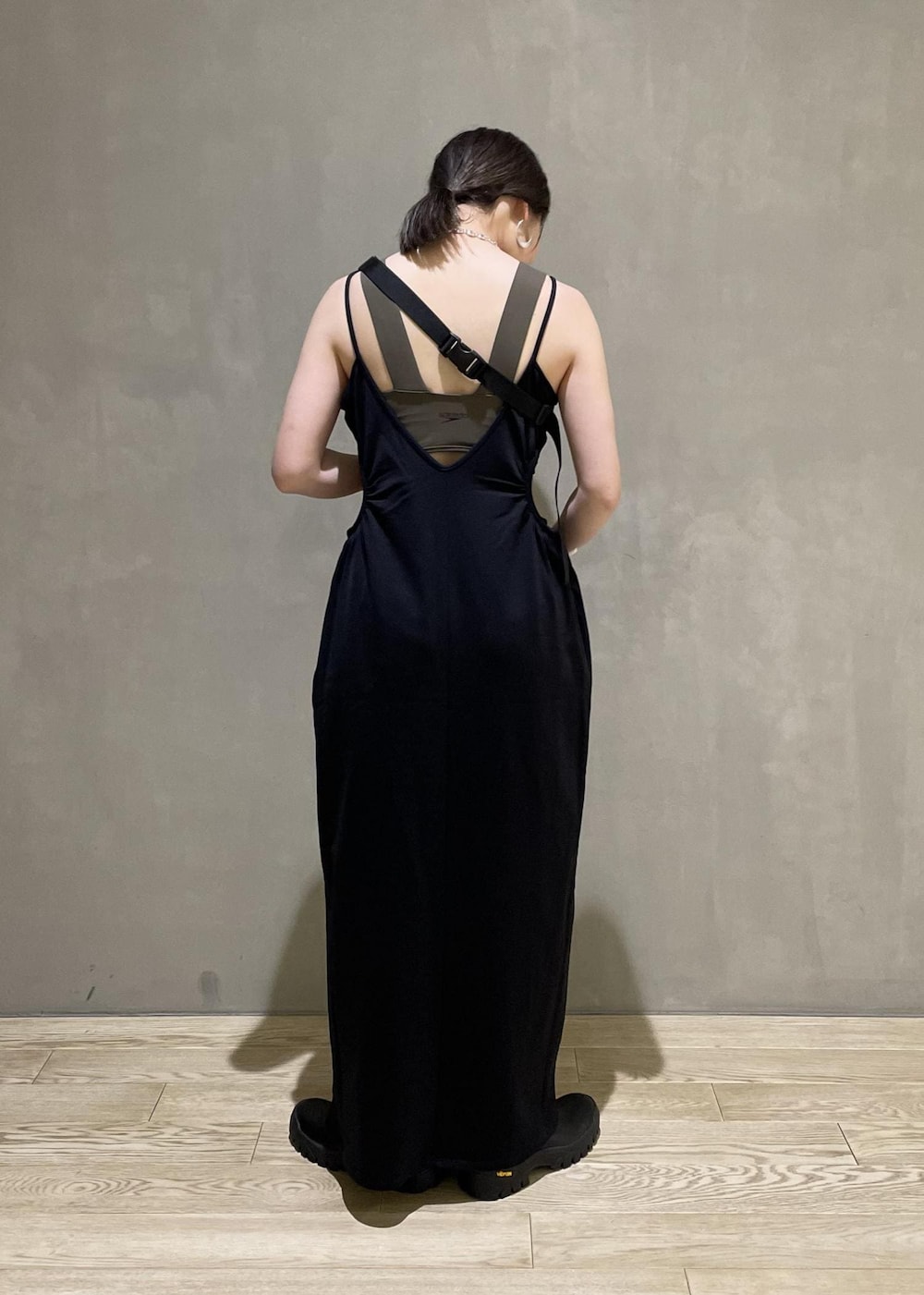 グレー系のボディバッグ/ウエストポーチ、ブラック系のブーツ、ブラック系のワンピースを着用したレディースの春コーディネートの3枚目の写真