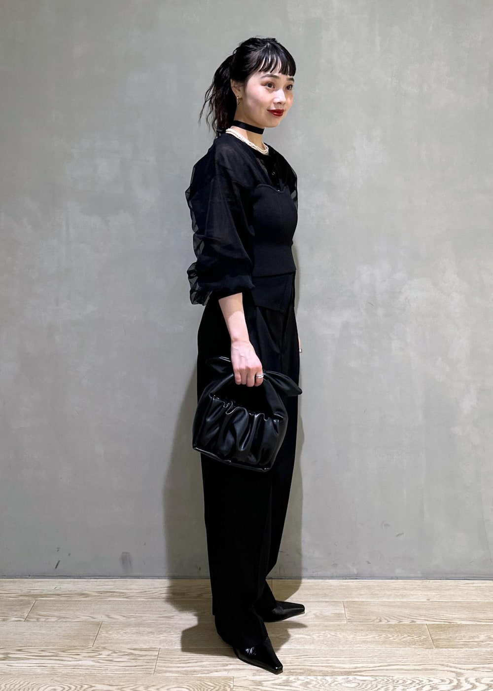 ブラック系のカーディガン/ボレロ、ブラック系のスラックス、ブラック系のショルダーバッグを着用したレディースの夏コーディネートの3枚目の写真