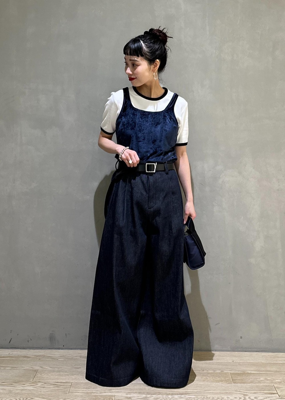 ブルー系のデニムパンツ、ブルー系のショルダーバッグ、ブルー系のタンクトップを着用したレディースの夏コーディネートの3枚目の写真