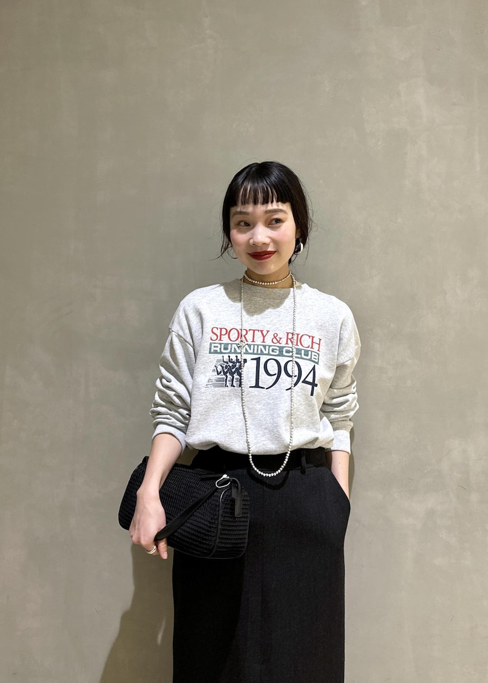 ブラック系のハンドバッグ、ブラック系のスカートを着用したレディースの秋コーディネートの6枚目の写真