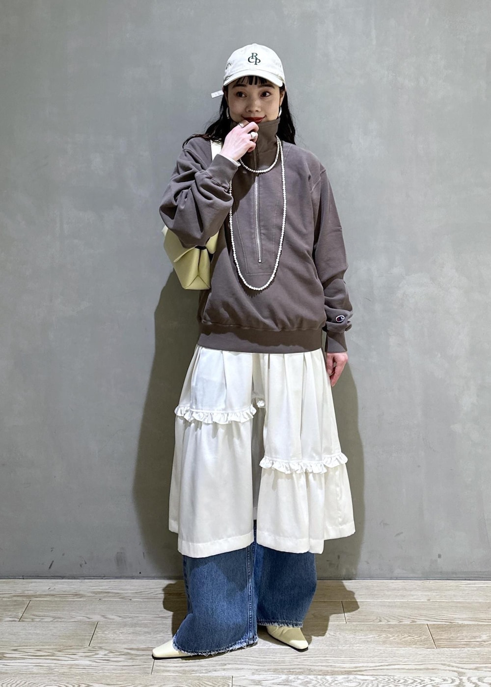 ホワイト系のスカート、ブラウン系のスウェット、ベージュ系のサンダルを着用したレディースの冬コーディネートの5枚目の写真