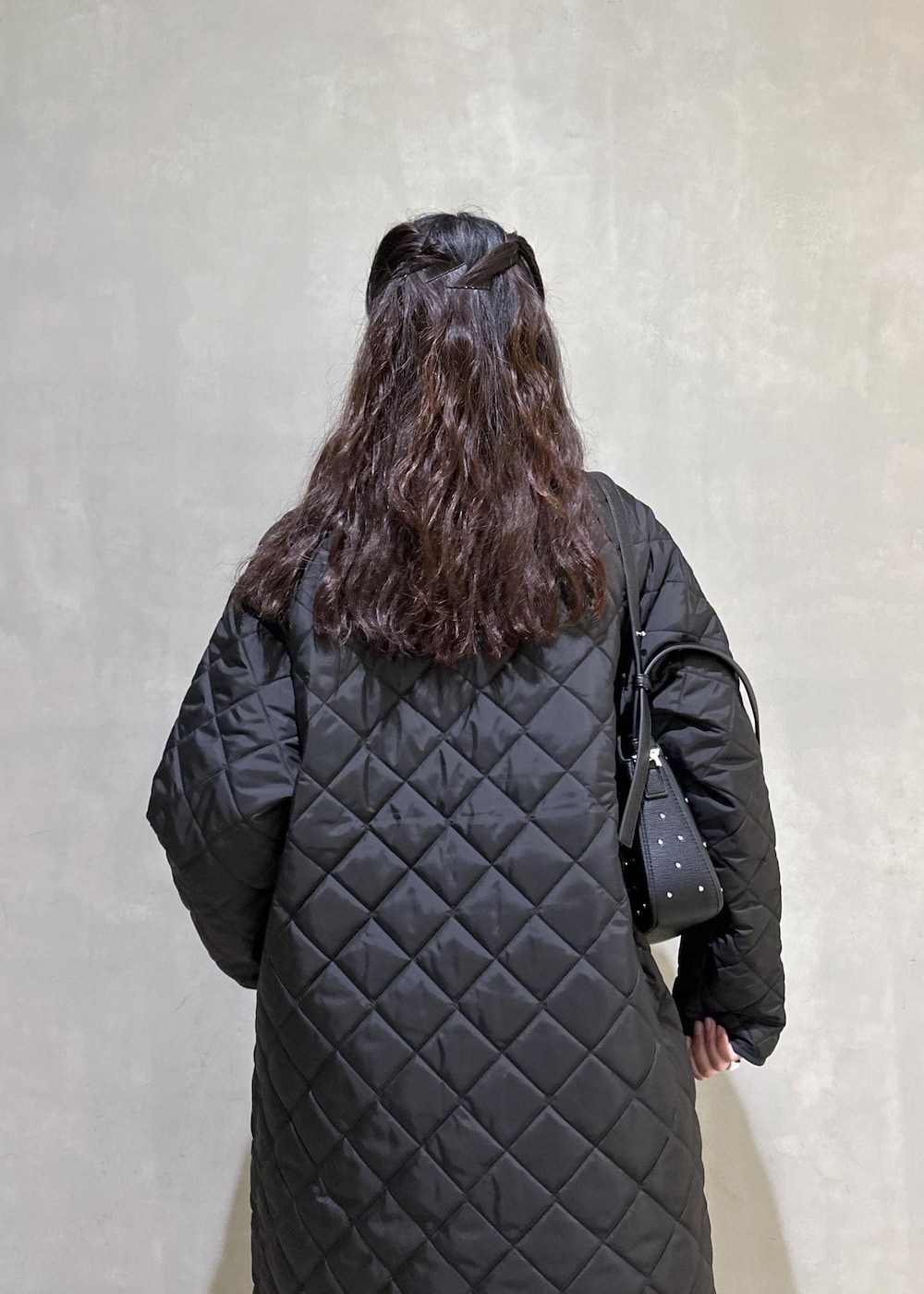 ブラック系のニット/セーター、ブラック系のナイロンジャケット、ブラック系のブーツを着用したレディースの秋コーディネートの8枚目の写真