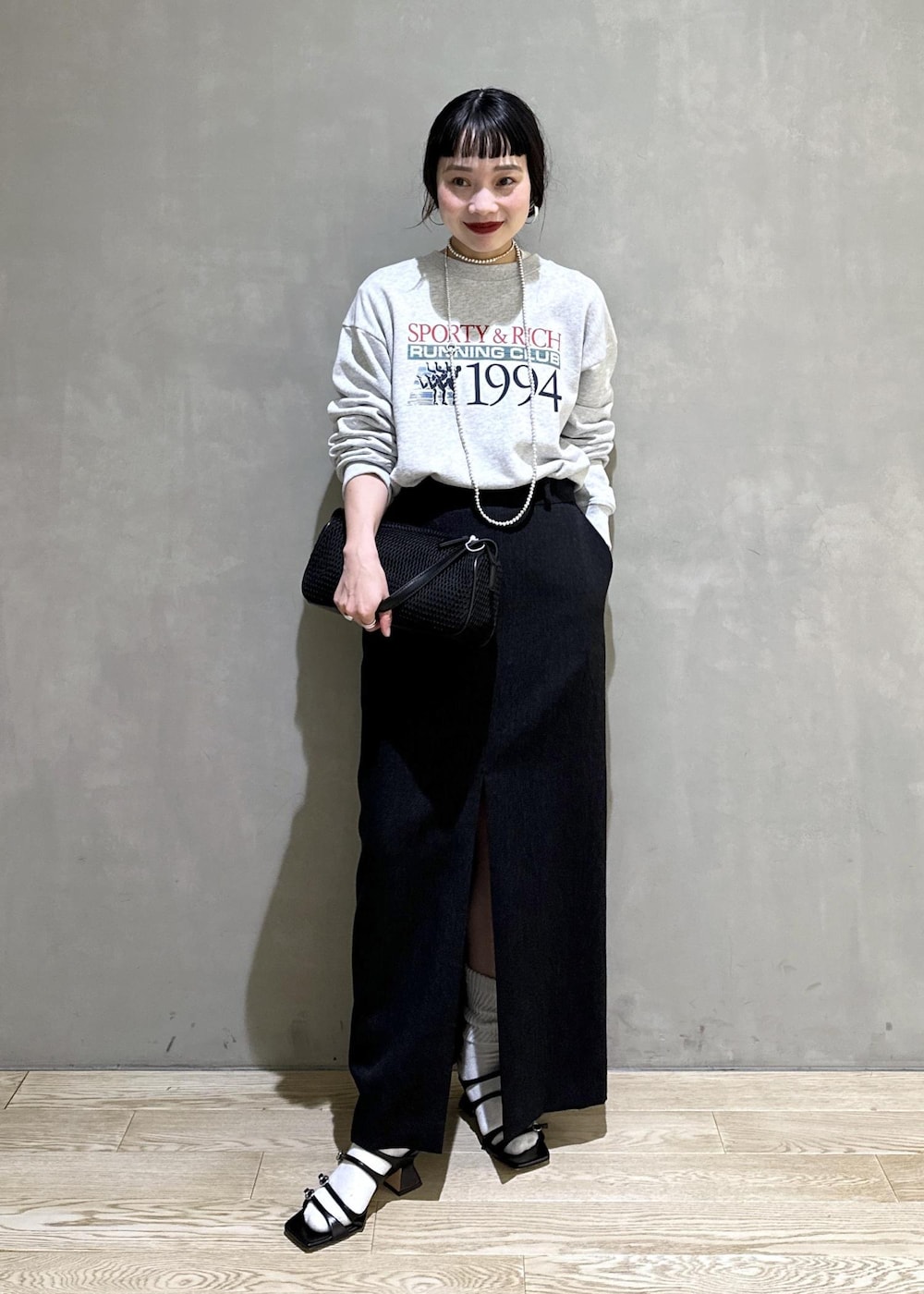 ブラック系のハンドバッグ、ブラック系のスカートを着用したレディースの秋コーディネートの4枚目の写真