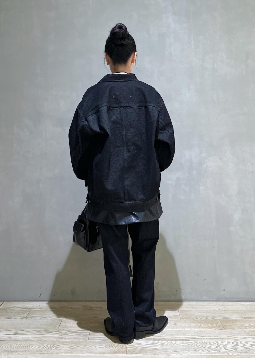 ブラック系のショルダーバッグ、ブラック系のデニムジャケット、ブラック系のデニムパンツを着用したレディースの冬コーディネートの5枚目の写真