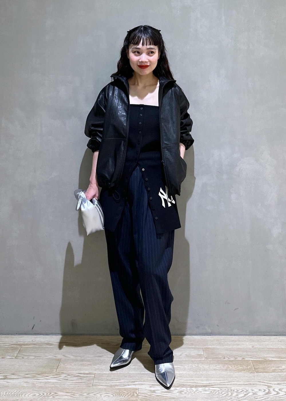 シルバー系のショルダーバッグ、シルバー系のブーツ、ブラック系のスラックスを着用したレディースの秋コーディネートの3枚目の写真