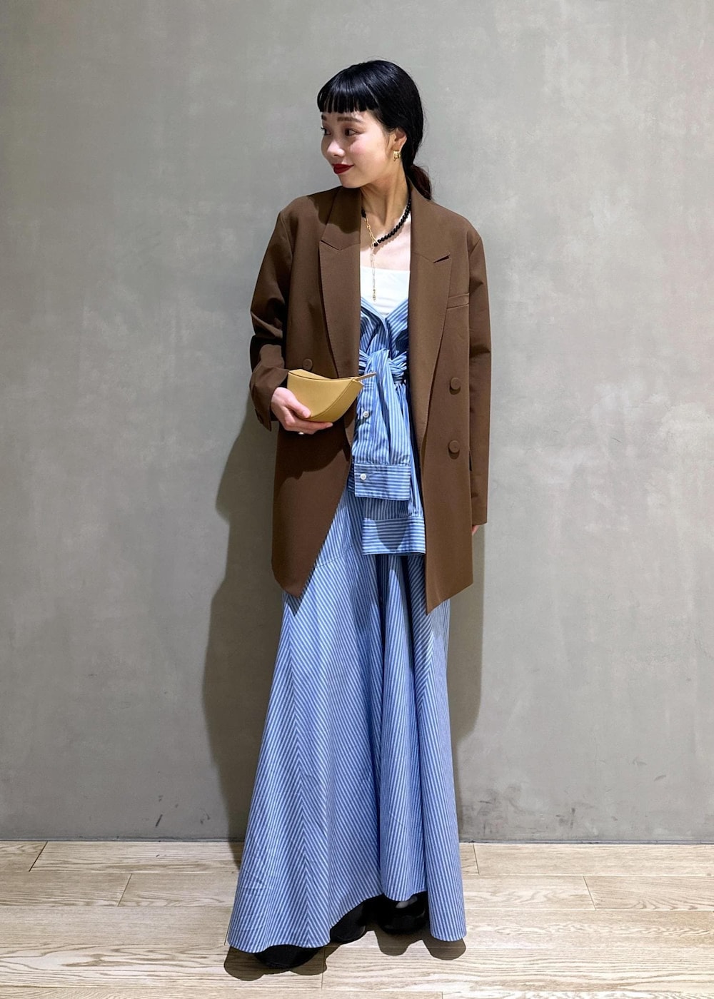 ブラック系のサンダル、ブラウン系のテーラードジャケット、ブルー系のシャツワンピースを着用したレディースの秋コーディネートの2枚目の写真