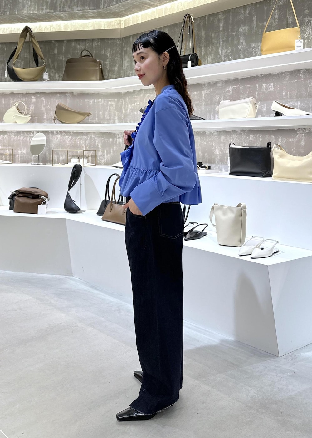 ブラック系のショルダーバッグ、ブルー系のデニムパンツ、ブルー系のシャツ/ブラウスを着用したレディースの春コーディネートの2枚目の写真