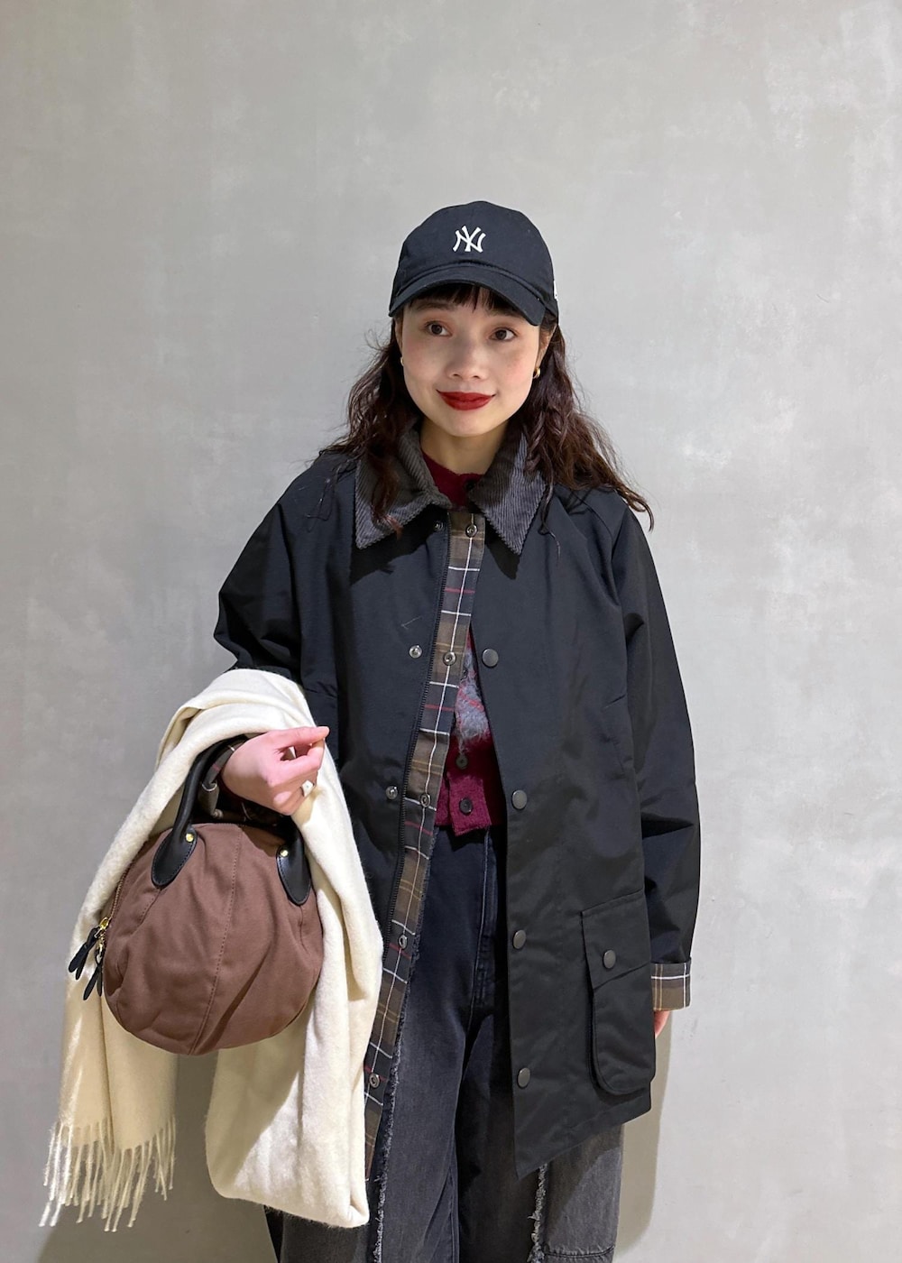 ブラック系のブルゾン、ブラック系のローファー、ブラック系のデニムパンツを着用したレディースの冬コーディネートの6枚目の写真