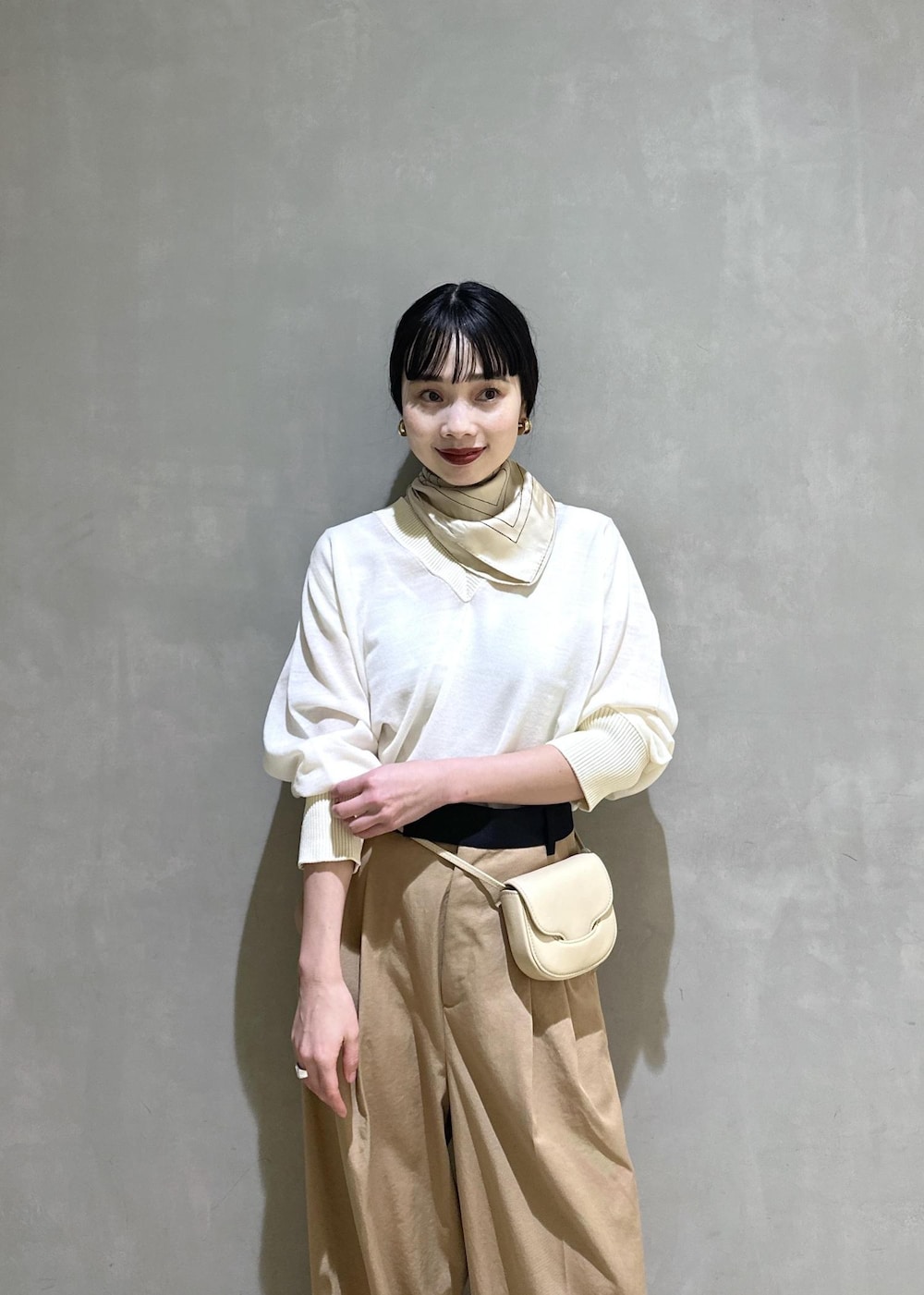 ベージュ系のショルダーバッグ、ベージュ系のブーツ、イエロー系のその他パンツを着用したレディースの秋コーディネートの6枚目の写真