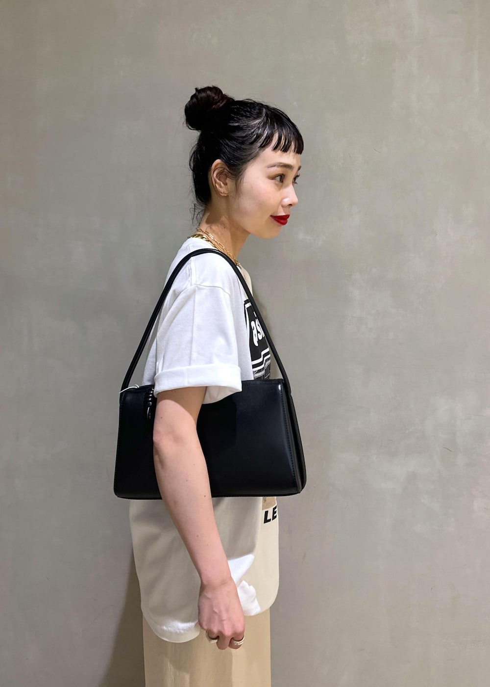 ブラック系のサンダル、ホワイト系のスカート、ブラック系のハンドバッグを着用したレディースの夏コーディネートの9枚目の写真